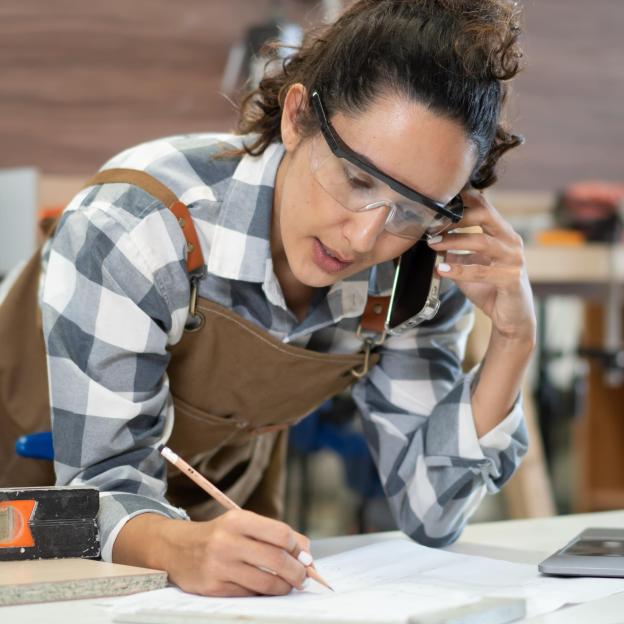 Femme menuisière qui écrit quelque chose sur une feuille