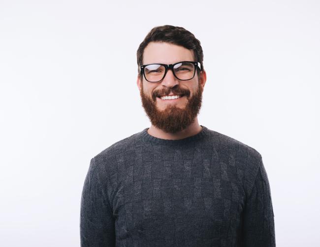 homme souriant barbu avec des lunettes de vue