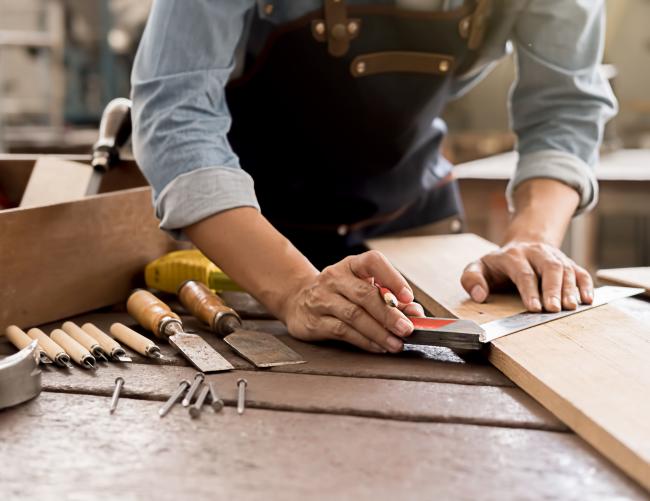 des mains qui font un travail sur bois