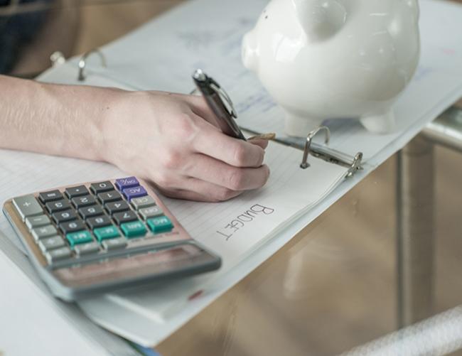 Photo d'illustration pour la thématique financer sa formation avec une main et une calculatrice en gros plan