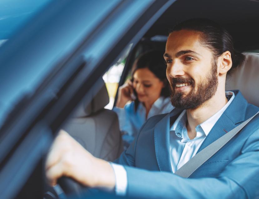 image d'un homme chauffeur VTC qui conduit une femme au téléphone