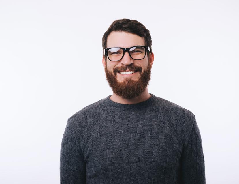 homme souriant barbu avec des lunettes de vue