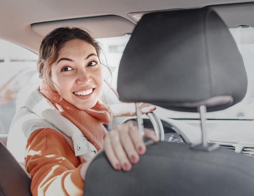 image d'une femme chauffeur de taxi qui se retourne au volant