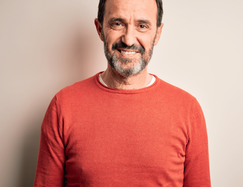 homme souriant avec une barbe et un pull orange 
