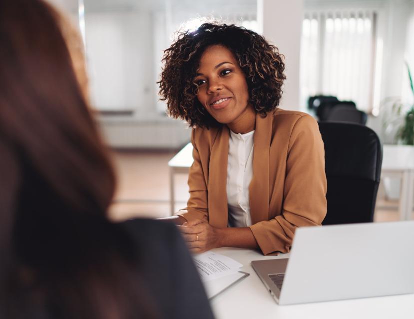 Jeune femme assise à un bureau qui discute