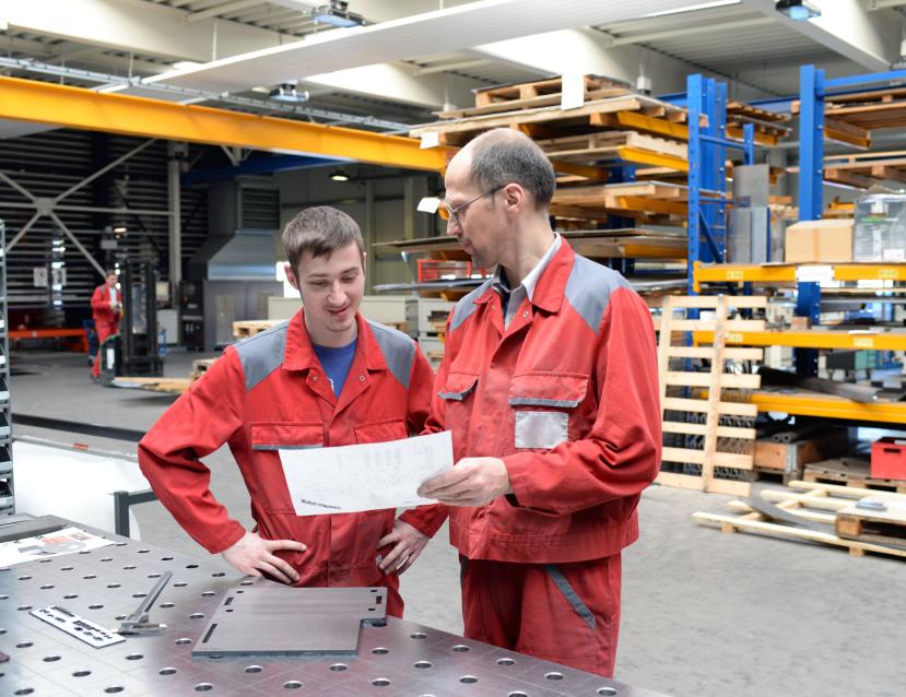 un apprenti avec son tuteur dans un atelier