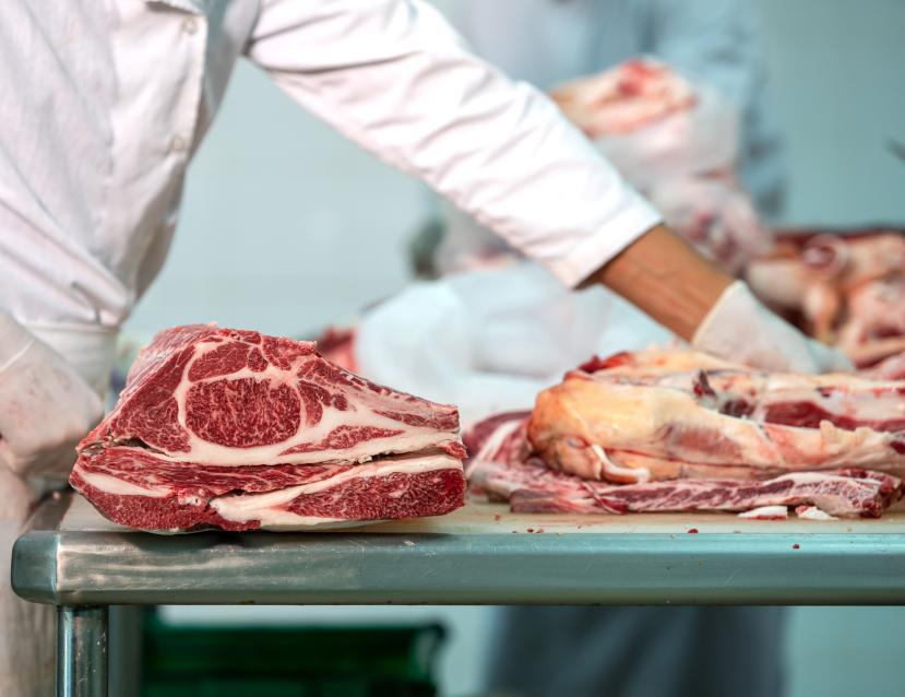 un boucher qui coupe des morceaux de viande