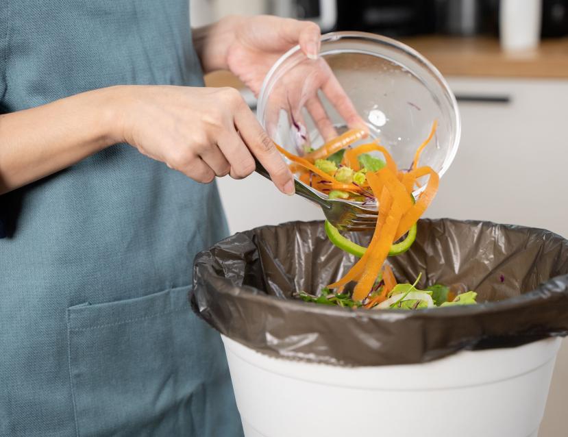 Des déchets alimentaires sont jetés dans une poubelle