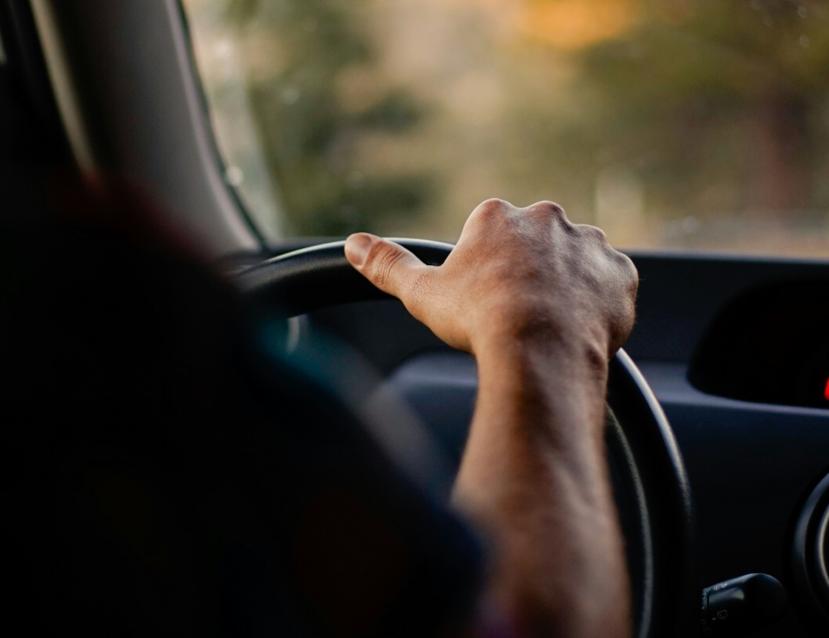 Plan rapproché sur le volant d'un homme en train de conduire