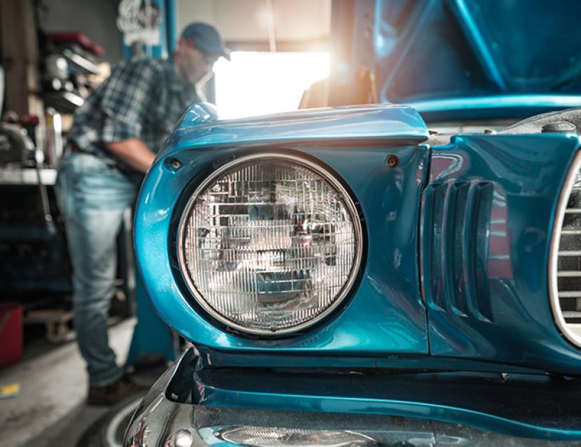 Photo d'un mécanicien au travail sur une voiture ancienne