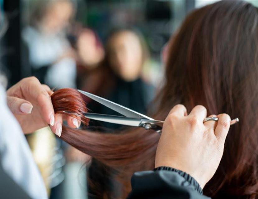 Photo en gros plan du geste de coupe d'un coiffeur avec ses ciseaux