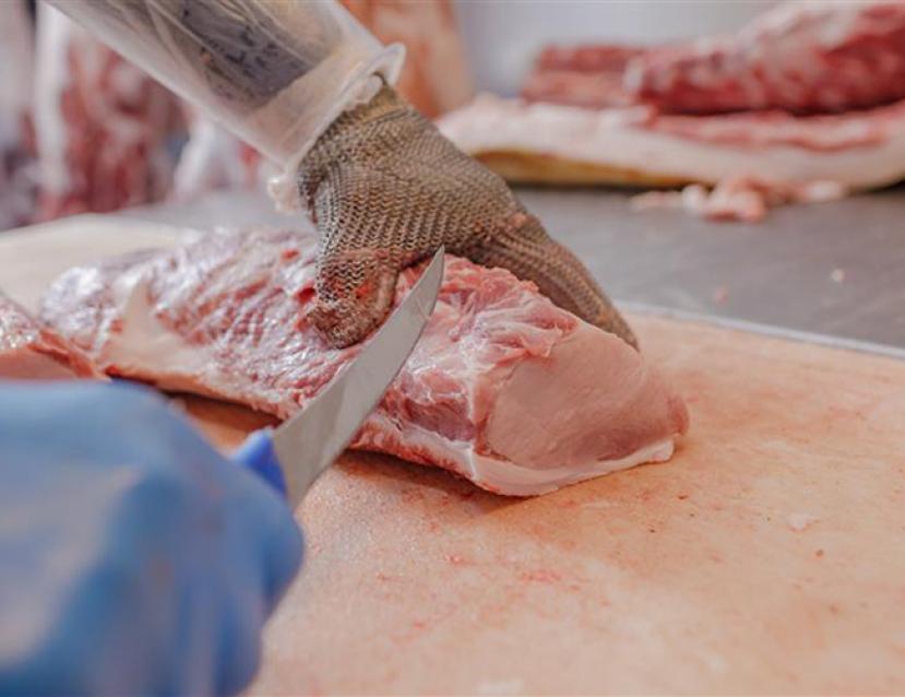 Photo en gros plan sur le travail de découpe de viande par apprenti en CTM Boucher Charcutier Traiteur