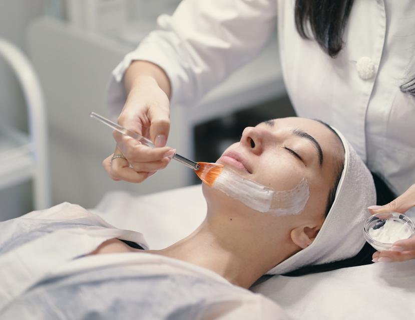 Femme en train d'appliquer un masque à une cliente