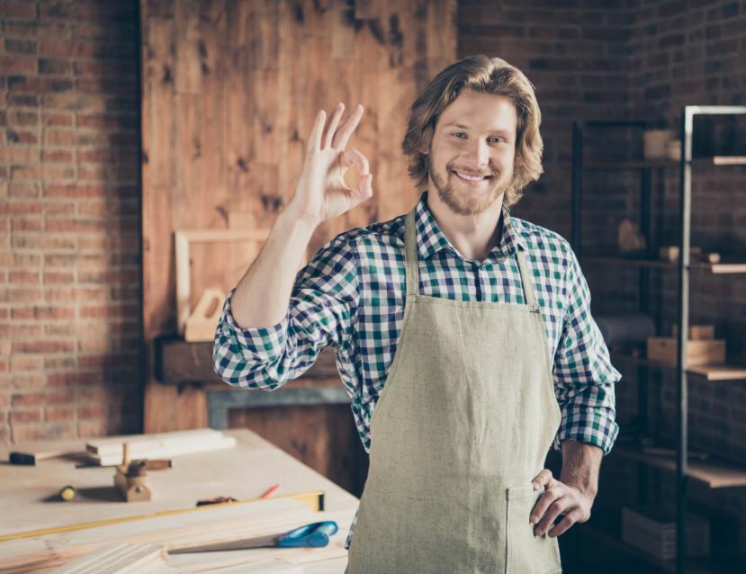 Homme souriant qui fait un signe 'ok' avec ses doigts