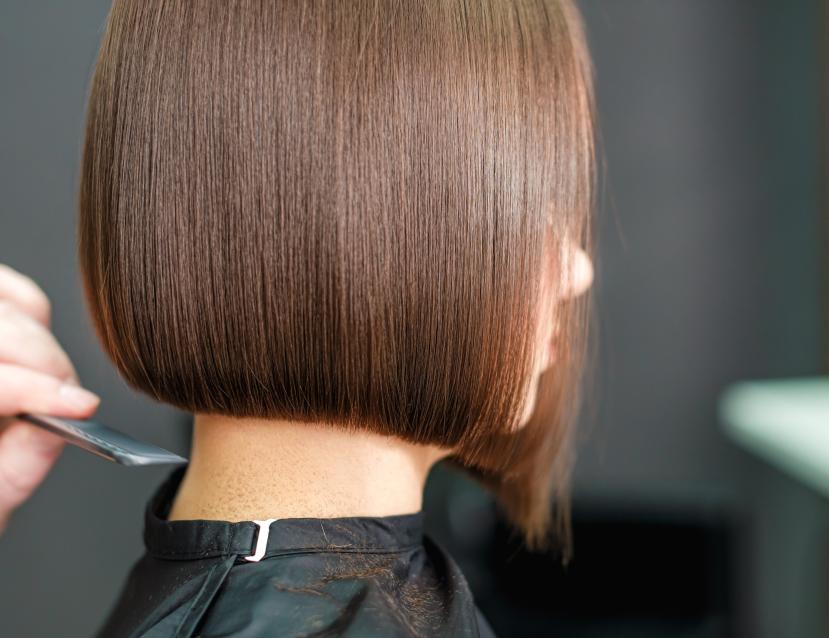 Femme brune avec un carré en train de se faire coupé les cheveux 