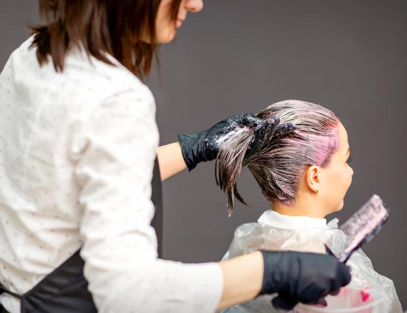 Coiffeuse en train d'appliquer une couleur à une cliente 