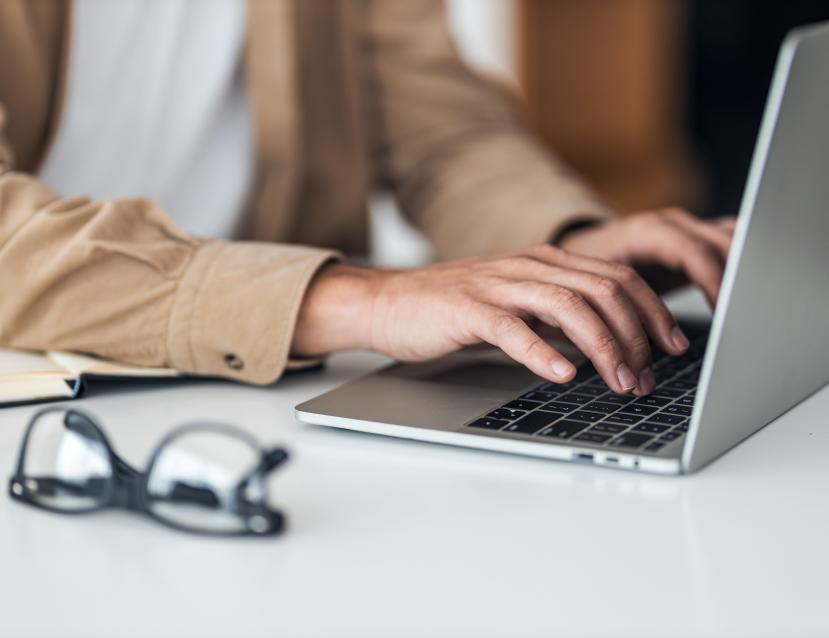 Personne tapant sur le clavier d'un ordinateur portable