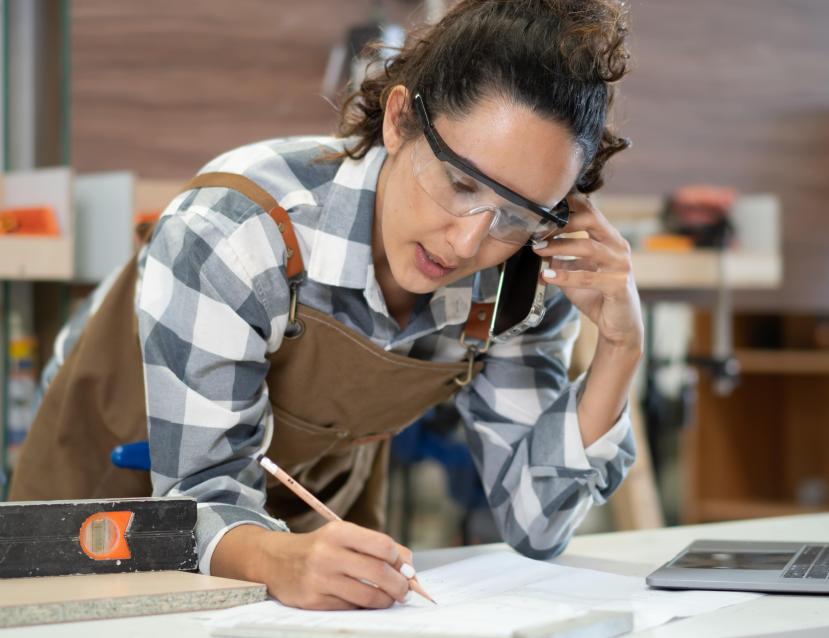 Femme menuisière qui écrit quelque chose sur une feuille
