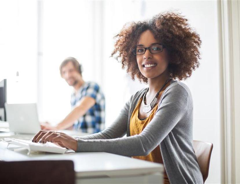 Photo d'une jeune femme travaillant son dossier de VAE sur ordinateur
