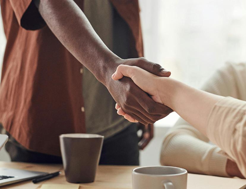 Photo d'une poignée de main entre un jeune apprenti et son employeur
