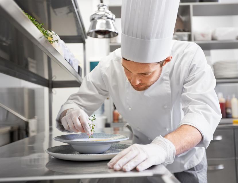 une personne de cuisine sert une soupe