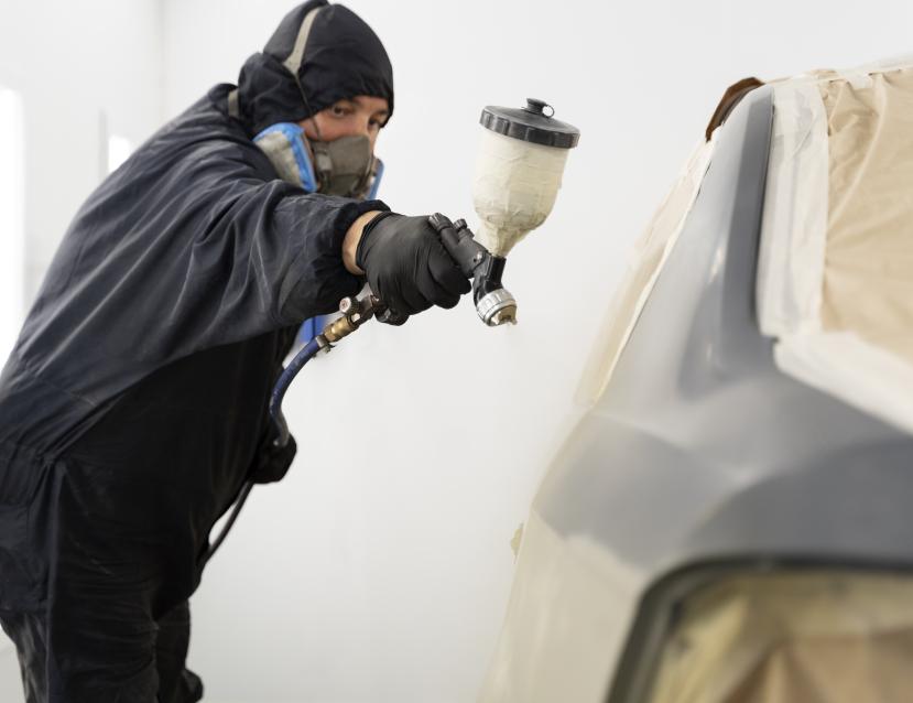 employe-de-service-peignant-une-voiture-en-service-automobile