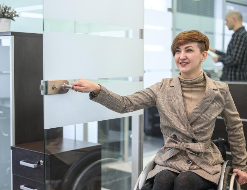 personne en fauteuil qui ouvre une porte 