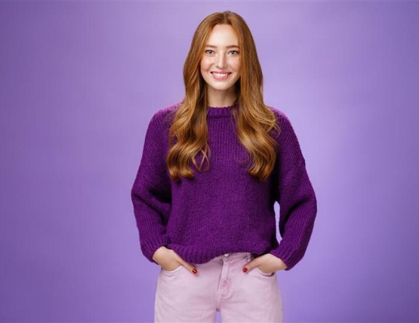 Femme qui sourit et croise les bras habillé en violet