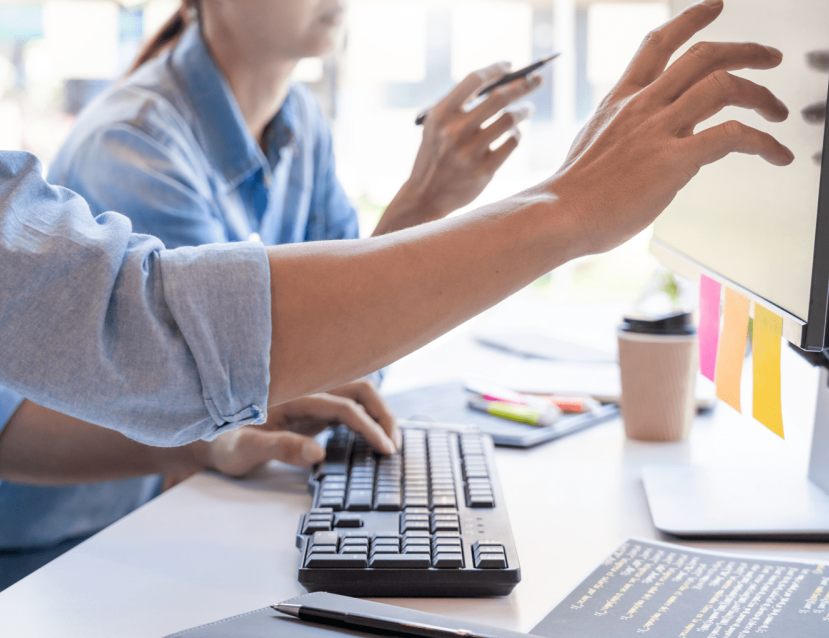 Photo de deux personnes devant un écran d'ordinateur pour une formation CMA Formation