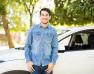 homme souriant devant une voiture blanche