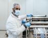 homme boucher avec un masque et une charlotte dans son atelier