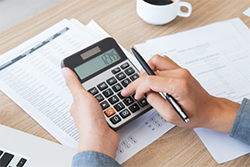 Photo en gros plan de main avec une calculatrice